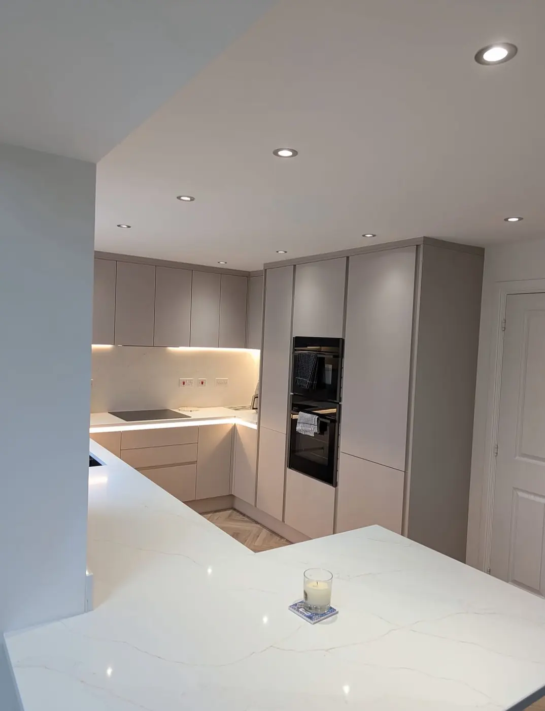 Handleless kitchen with tall housing units and built-in ovens
