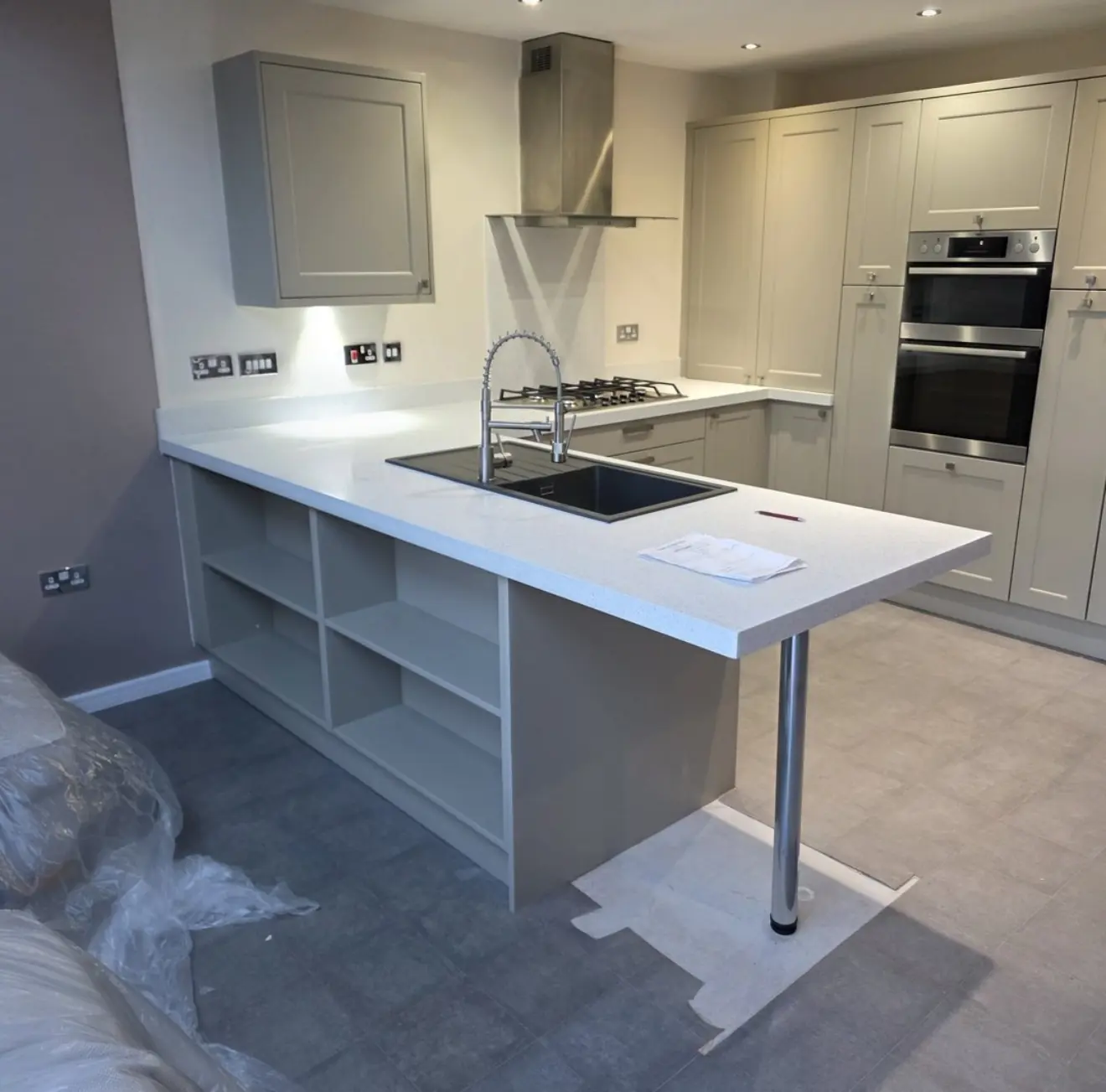 Shaker kitchen peninsula with open shelving, freshly installed